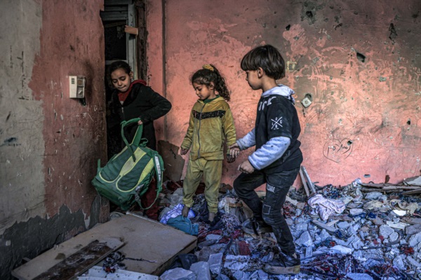 Niños entre los escombros en una habitación de un edificio destruido por los bombardeos israelíes en Rafah, en el sur de la Franja de Gaza.