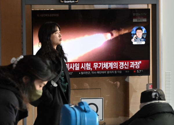 Varias personas observan una pantalla de televisión que muestra un noticiario con imágenes de una prueba de misiles norcoreana.