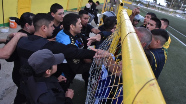 Descontrol. Personal policial evitando la agresión en la zona de vestuarios.