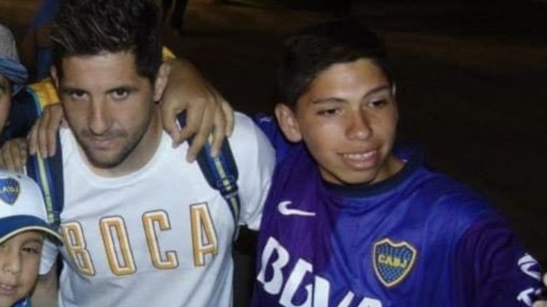 Carlos Palacios en 2013 con la camiseta de Boca y una foto con Agustín Orión.