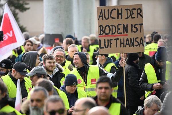 Empleados de la aerolínea y miembros del sindicato alemán Verdi protestan con una pancarta en la que se lee "También el suelo es Lufthansa.