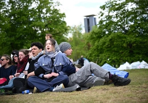 Activistas sentados en el suelo en un campamento de protesta pro-palestino cerca de la cancillería.