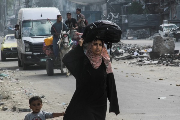 Una mujer palestina desplazada, Lleva sus pertenencias en la cabeza mientras se dirige hacia la ciudad de Gaza. REUTERS/Mahmoud Issa.