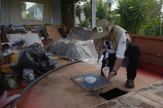 Un trabajador de vigilancia ambiental inspecciona un barco durante el combate contra el mosquito Aedes aegypti.
