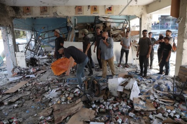 Personas inspeccionan los restos de una escuela administrada por la ONU que alberga a personas desplazadas después de que fuera atacada por el Ejército israelí.