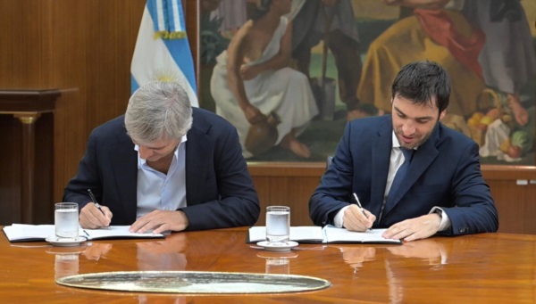 Caputo y Torres firmando el acuerdo.