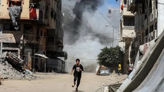Un niño palestino huye en medio de un bombardeo.