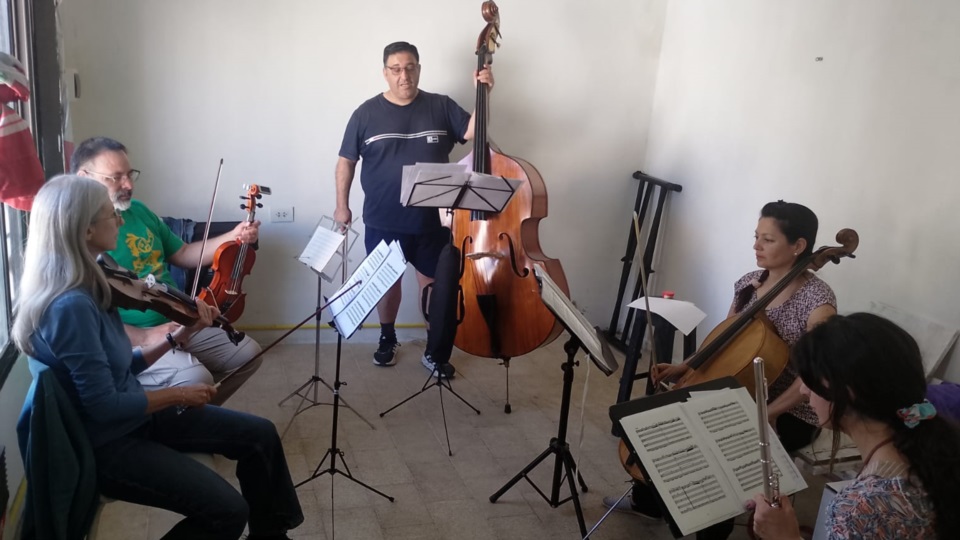 Los músicos, con el director Mauro Vázquez con el contrabajo, en un breve alto en sus ensayos.