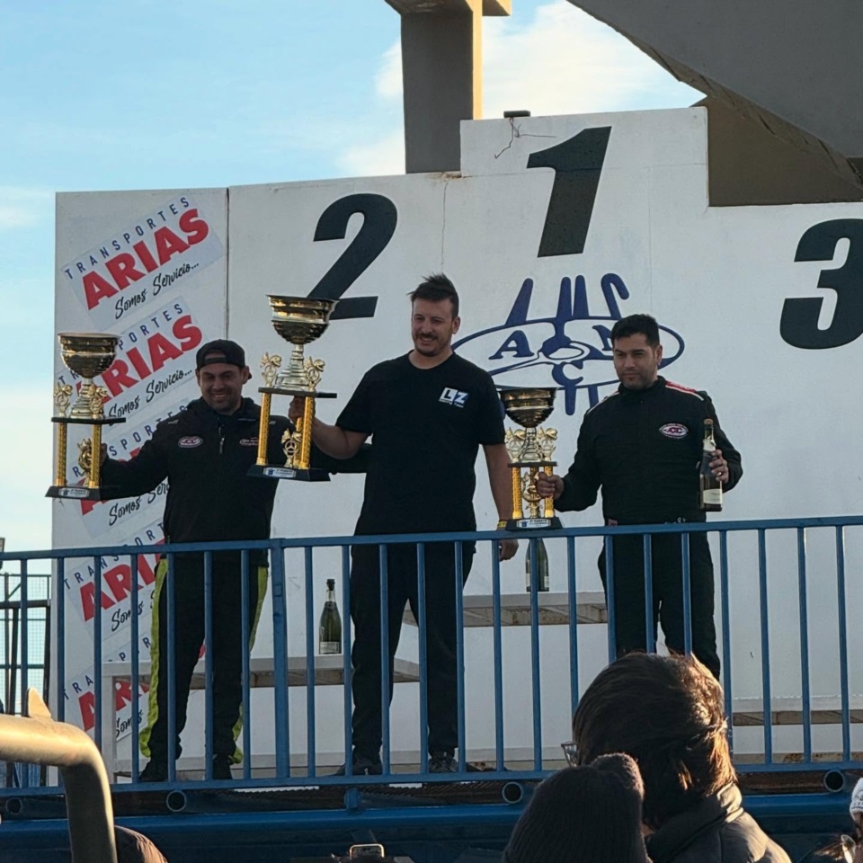 Emiliano López rodeado de los hermanos Axel y Amílcar Olíver en la coronación del TC Patagónico.