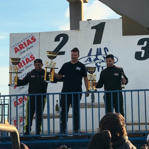 Emiliano López rodeado de los hermanos Axel y Amílcar Olíver en la coronación del TC Patagónico.