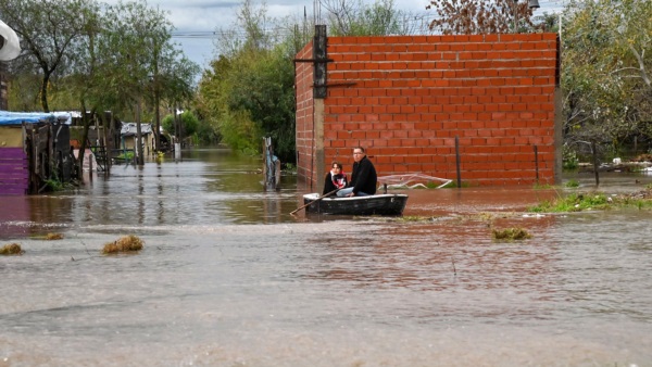 Vecinos utilizando un bote en medio del temporal.