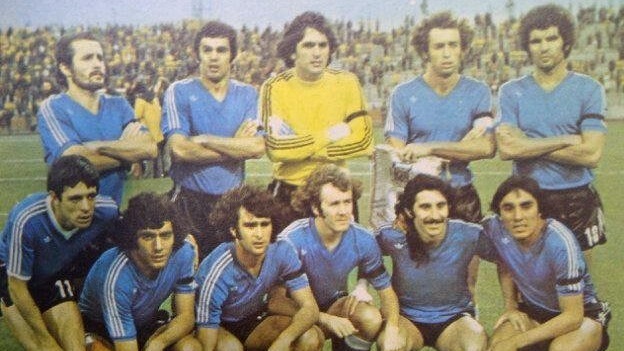 El equipo ante RDA con camiseta azul y cinta negra.