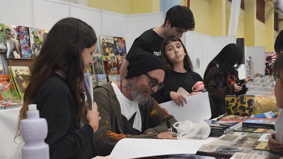 Juan Chavetta compartiendo sus dibujos en la Feria del Libro de Trelew en 2024.