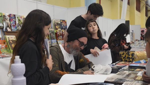 Juan Chavetta compartiendo sus dibujos en la Feria del Libro de Trelew en 2024.