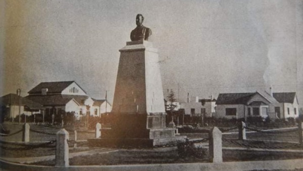El busto de Guillermo Rawson y de fondo la entonces escuela N° 1 (hoy 4).