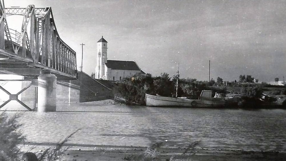 La iglesia de fondo, el puente de ingreso, un barco y el rio. Rawson sintetizado.