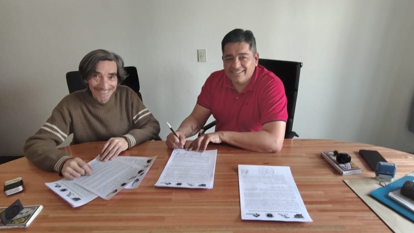 Sergio Guajardo y Alfredo Roa firmando el convenio.