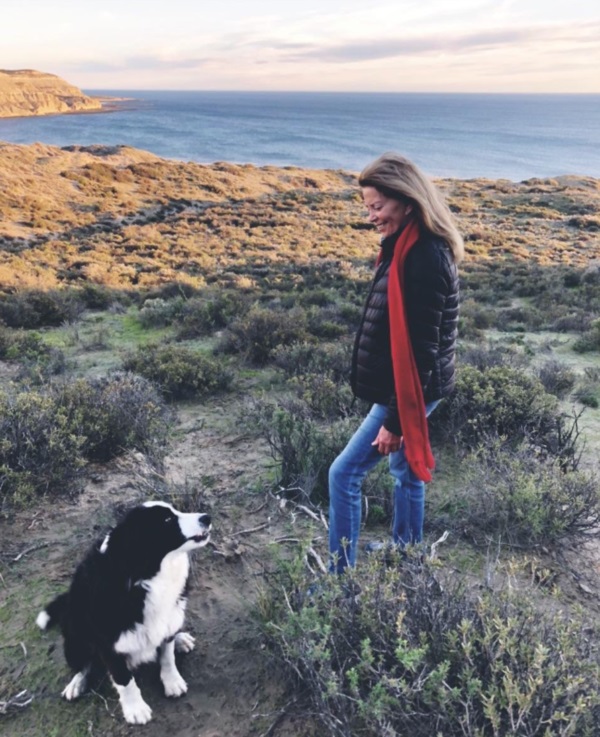 "La señora", como se la conoce, con uno de sus perros y el Golfo Nuevo de fondo.