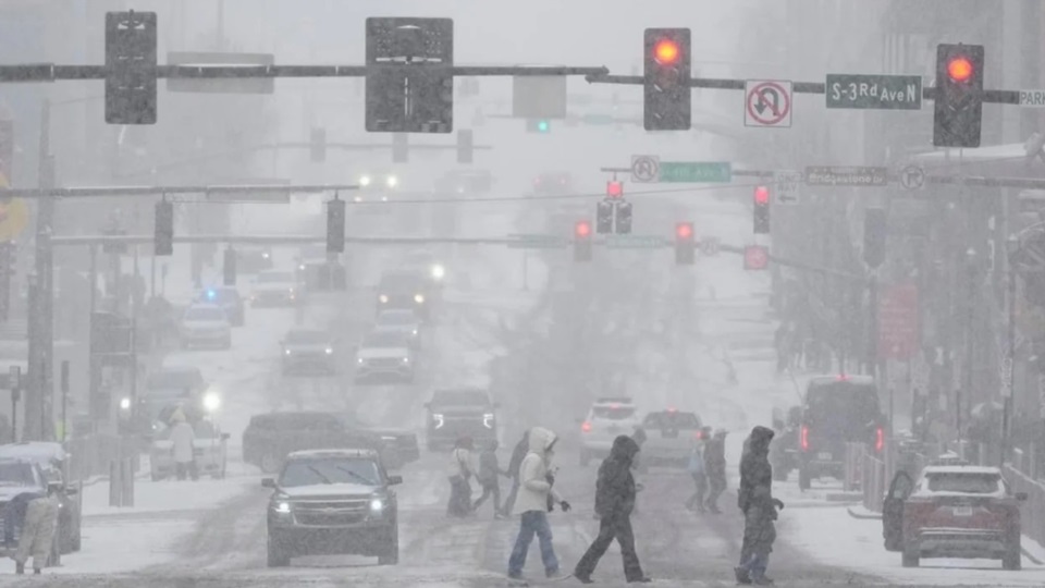 Peatones cruzan la calle en medio de la tormenta invernal en Nashville, estado de Tennessee. 
