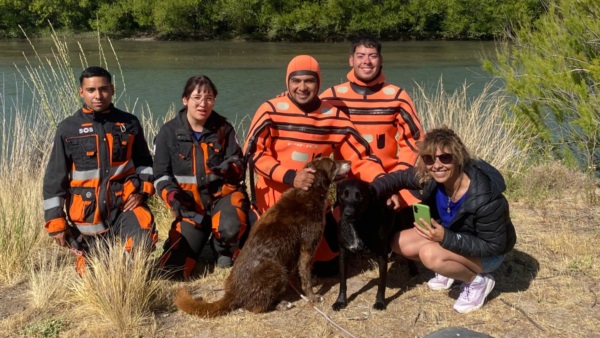 Los bomberos junto al perro rescatado.