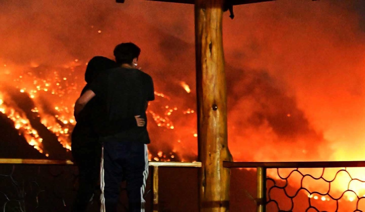 El Hoyo. Una pareja observa aterrada el avance del fuego sobre el cerro Pirque (Maxi Jonas)