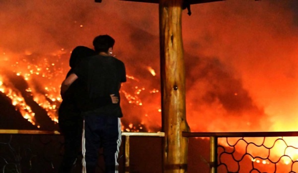 El Hoyo. Una pareja observa aterrada el avance del fuego sobre el cerro Pirque (Maxi Jonas)