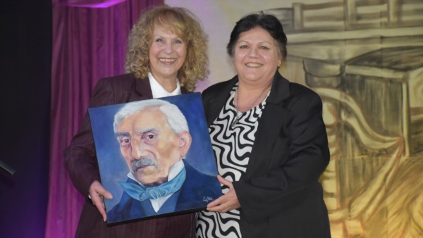 na María (Perla) Piuma presidenta de la Biblioteca Ricardo Berwyn recibiendo la obra donada por Claudia Bau.