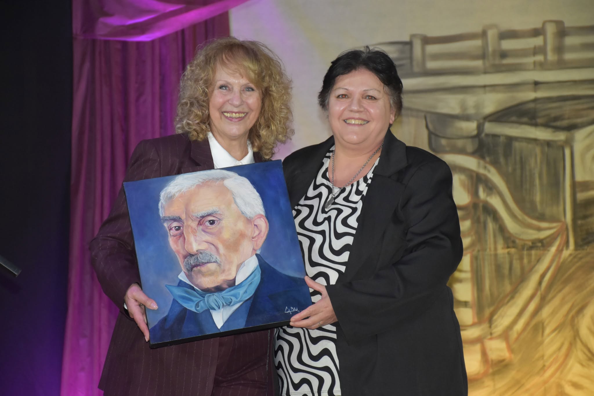 Ana María (Perla) Piuma presidenta de la Biblioteca Ricardo Berwyn recibe la obra donada por Claudia Bau.