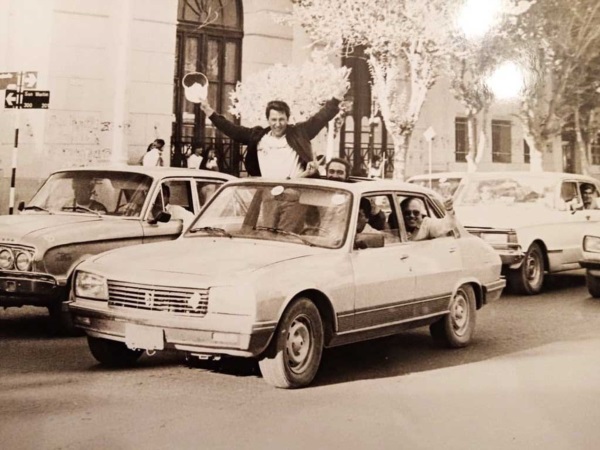 Kuky festejando un triunfo elector a bordo de un Peugeot 504.