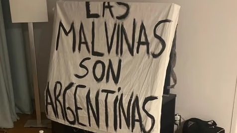 La bandera, confeccionada sobre unas sábanas de hotel.