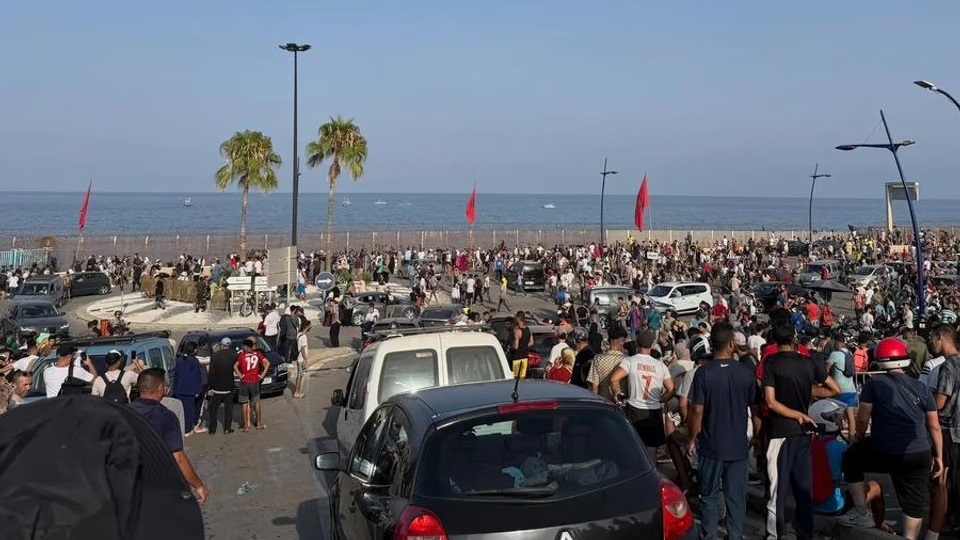 Personas se reúnen en el lado marroquí de la frontera con Ceuta, en el norte de África, preparándose para cruzar.