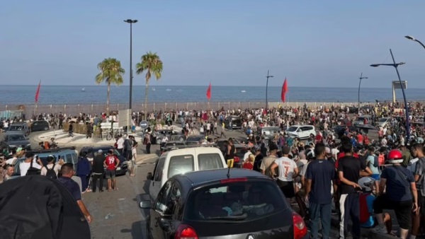 Personas se reúnen en el lado marroquí de la frontera con Ceuta, en el norte de África, preparándose para cruzar.