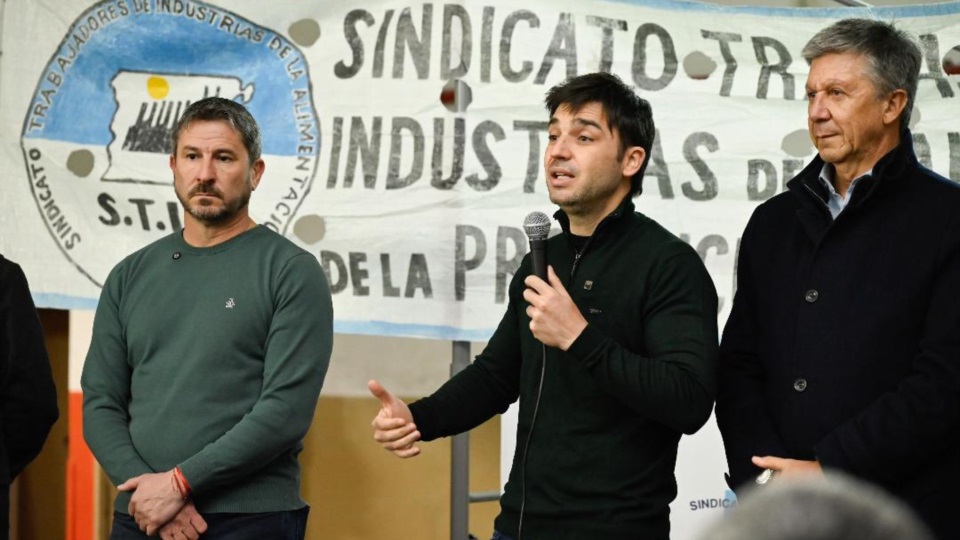 Habla Torres. A su lado Menna y Merino.