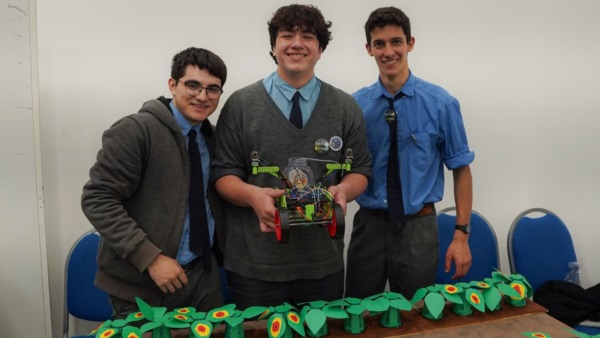Los tres destacados alumnos con su creación robótica.